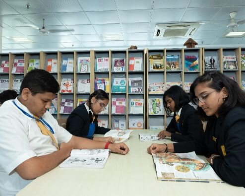 ICSE & ISC school students reading books in library.
